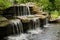A two level man made stone waterfall cascading into a pond