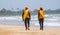 Two Lifeguards on duty at the tropical beach, Both carrying rescue tubes on their shoulders and walking on the tropical sandy