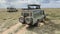 Two lionesses lie in the shadow of a safari jeep. Safari in Tanzania. The amazing nature of Africa