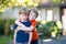 Two little active school kids boys, twins and siblings hugging on summer day