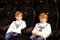 Two little adorable blonde kid boys waiting for a film at cinema. Siblings, twins and brothers having fun with activity