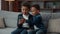 Two little African American siblings boys children kids little brothers with mobile phone smartphone playing game online