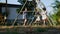 Two little Asian baby girls, 3 and 2 years old sisters, riding swings at a playground with help from their mother