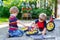 Two little boy friends, twins, learning to repair a bike and to to change a wheel.