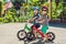 Two little boys children having fun on Balance Bike on a country tropical road