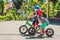 Two little boys children having fun on Balance Bike on a country tropical road