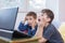 two little boys enjoying using internet on laptop