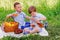 Two little boys friend, brother sit in the meadow and eat fruit