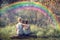 Two little boys friends holding and enjoying nature with rainbow in sunny summer day