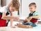 Two little boys knead the dough on the kitchen table