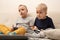 Two little boys play on the gaming console