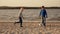 Two little boys playing football on the beach