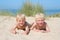 Two little boys playing with sand at the beach