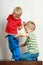 Two little boys siblings playing together on table