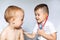 Two little boys using stethoscope. Children playing doctor and patient. Check the heartbeat.