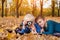 Two little brothers take a pictures on the camera. Lying in yellow autumn leaves. Fall day