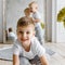 Two little child boys plaing and smiling on knitted carpeet on the wooden floor indoor. Knitted style in the interior. Warm and