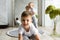 Two little child boys plaing and smiling on knitted carpeet on the wooden floor indoor. Knitted style in the interior. Warm and