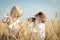 Two little children playing in a wheat field