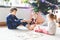 Two little chilren, cute toddler girl and school kid boy playing together card game by decorated Christmas tree. Happy