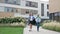 Two little classmates, a boy and a girl, are walking around the school yard in a good mood. School friendship.