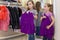 Two little cute girls near a mirror try on clothes