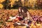 Two little cute girls plays in the autumn leaves in park