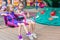 Two little cute sisters ride on carousel in the