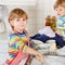 Two little funny helper in kitchen with washing dishes