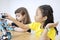 Two little girl constructing a Lego robot in classroom