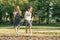 Two little girl friends schoolgirl 7, 8 years old play with soap bubbles on the meadow in the park