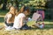 Two little girl friends schoolgirl learning sitting on a meadow in the park. Children with backpacks, books, notebooks. View from