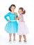 Two little girlfriends in the identical elegant dresses of different colors.