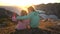 Two little girls admire the sunset or dawn sitting on the coastal rocks on the northern beach