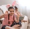 Two little girls with bunny ears posing with easter eggs