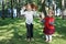 Two little girls catch soap bubbles among trees