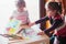 Two little girls drawing a colorful pictures using pencil crayon