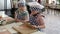 Two little girls dressed in uniforms chef learning to roll out the dough with a rolling pin on a board