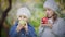 Two little girls eating red and green apples in a blooming Park