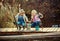 Two little girls with fishing rods, sitting on a wooden pontoon and bragging of caught fish