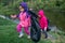 Two little girls with garbage bags on a trip to nature clean the environment