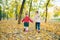 two little girls girlfriends playing at autumn city park holding hands