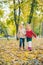 two little girls girlfriends playing at autumn city park holding hands