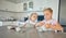 Two little girls having a tea party at home. Sibling sister friends wearing tiaras while playing with tea set and having