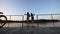 Two little girls jumps from a wooden footbridge into the river on a summer evening