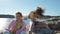 Two little girls play among the coastal rocks on the beach.