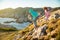 Two little girls play on rocky northern seashore.