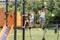 Two little girls playing on climbing net at  playground. Kids play and climb rope net on sunny summer day.