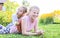 Two little girls playing on green grass in sunny summer day in countryside