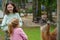 Two little girls, preschool and school sisters feeding fluffy furry alpacas lama. Happy excited children feeds guanaco